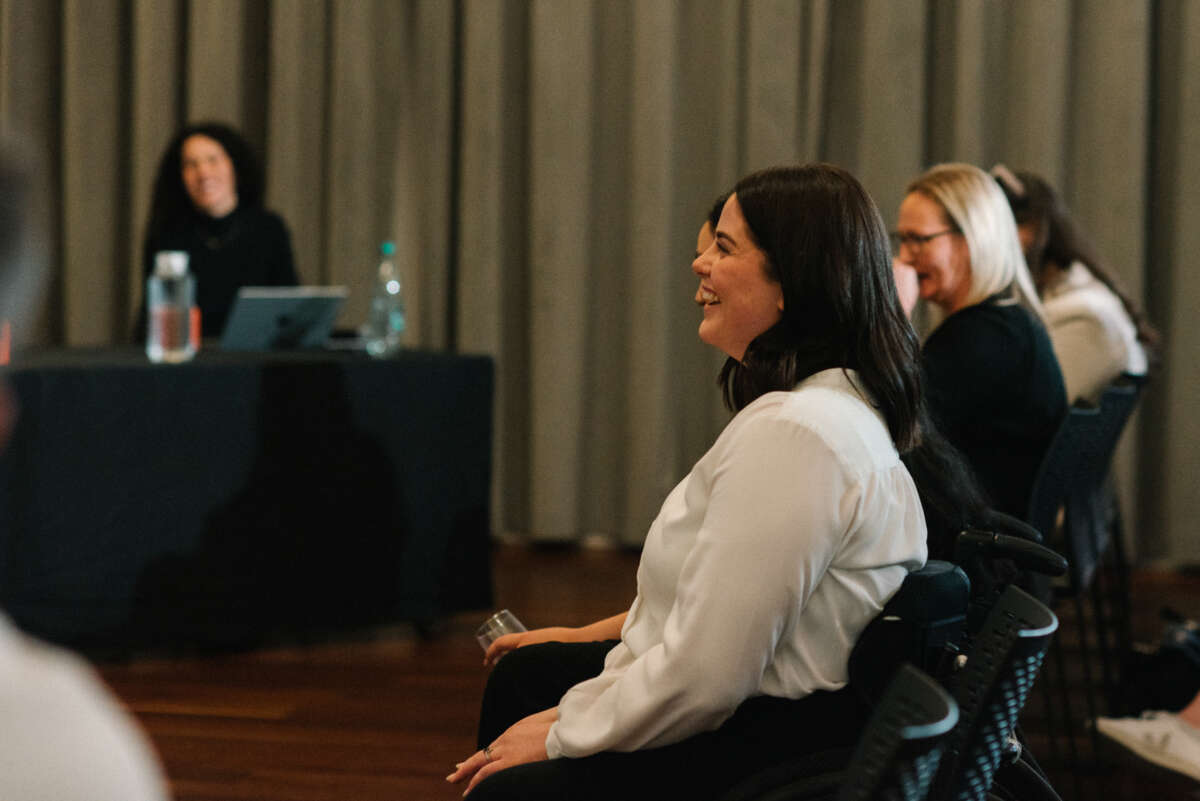 Image shows rebecca laughing while watching the inclusive code