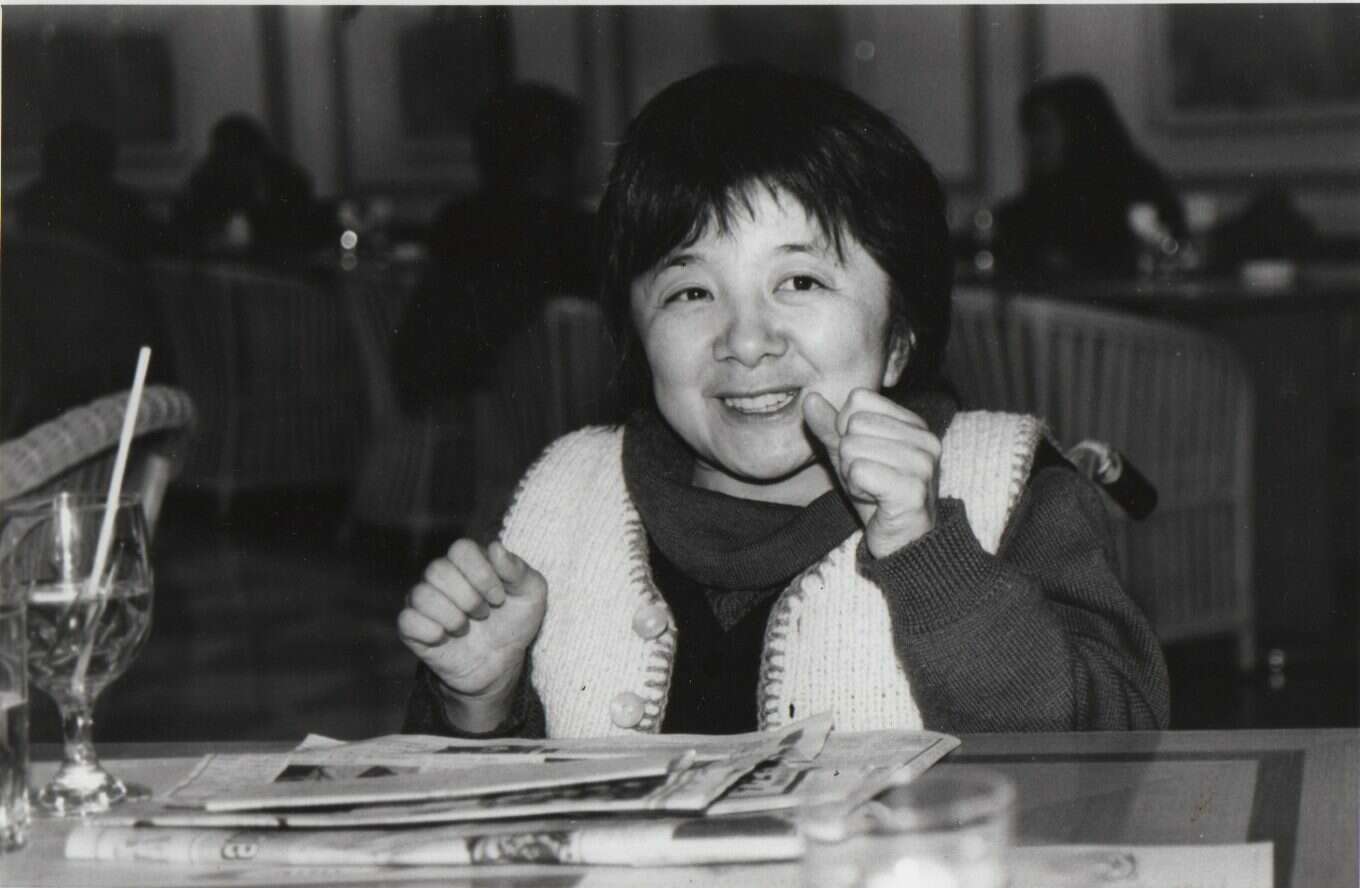 Black and white image of a woman at a dining table, she's Umi's mum