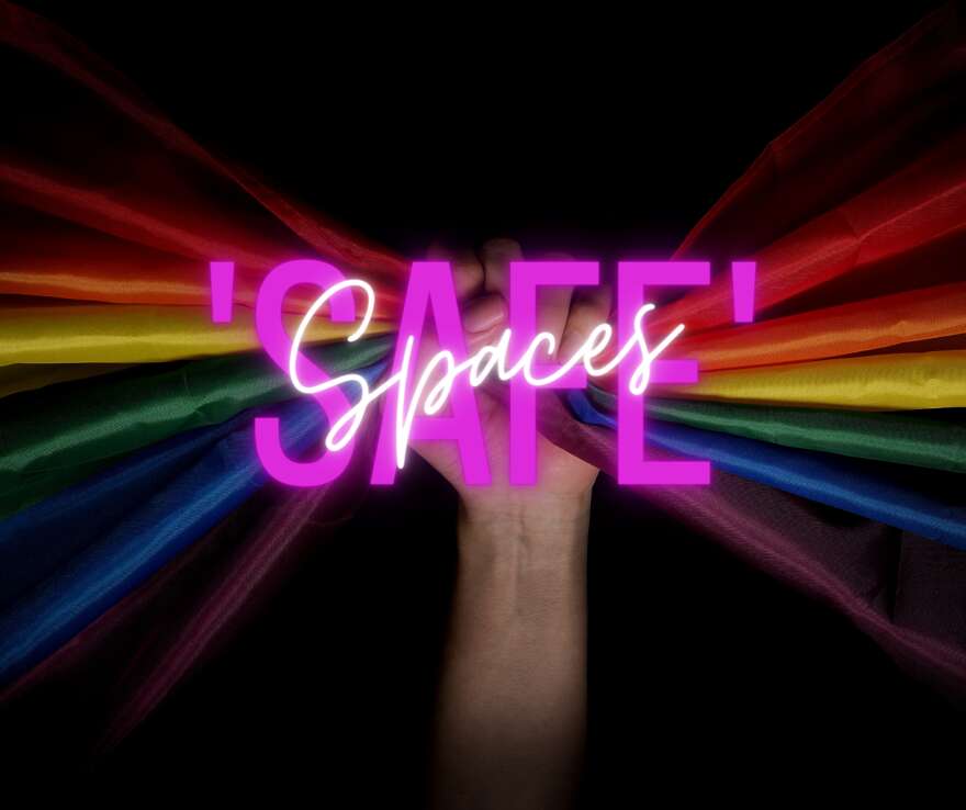 Image shows a hand raised in their holding only material in rainbow colours that disperse outwards. On top of this in Neon pink is the word 'SAFE', then on top of that is 'Spaces' in white