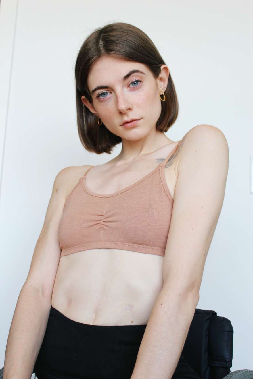 Portait with brown short hair and a pale sports bra