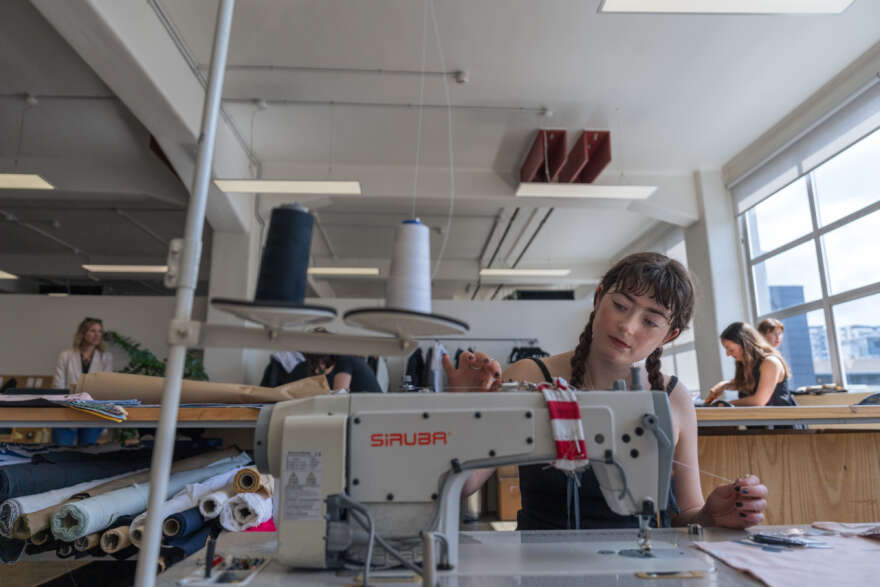 A young woman uses a sewing machine