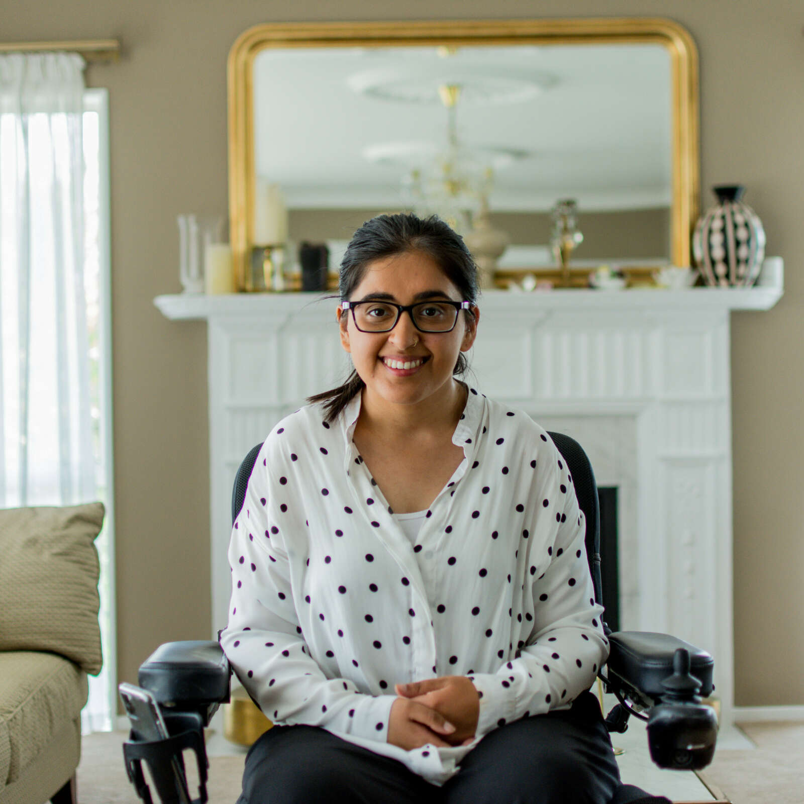 Latifa is in her home, she is in her wheelchair wearing a polka dot sweater
