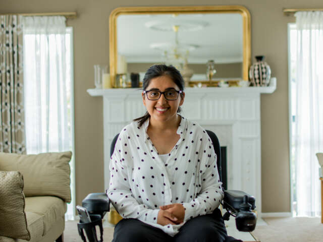 Latifa is in her home, she is in her wheelchair wearing a polka dot sweater