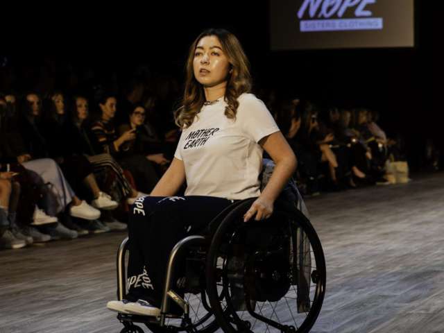 Olivia on a runway wearing jeans and a t-shirt