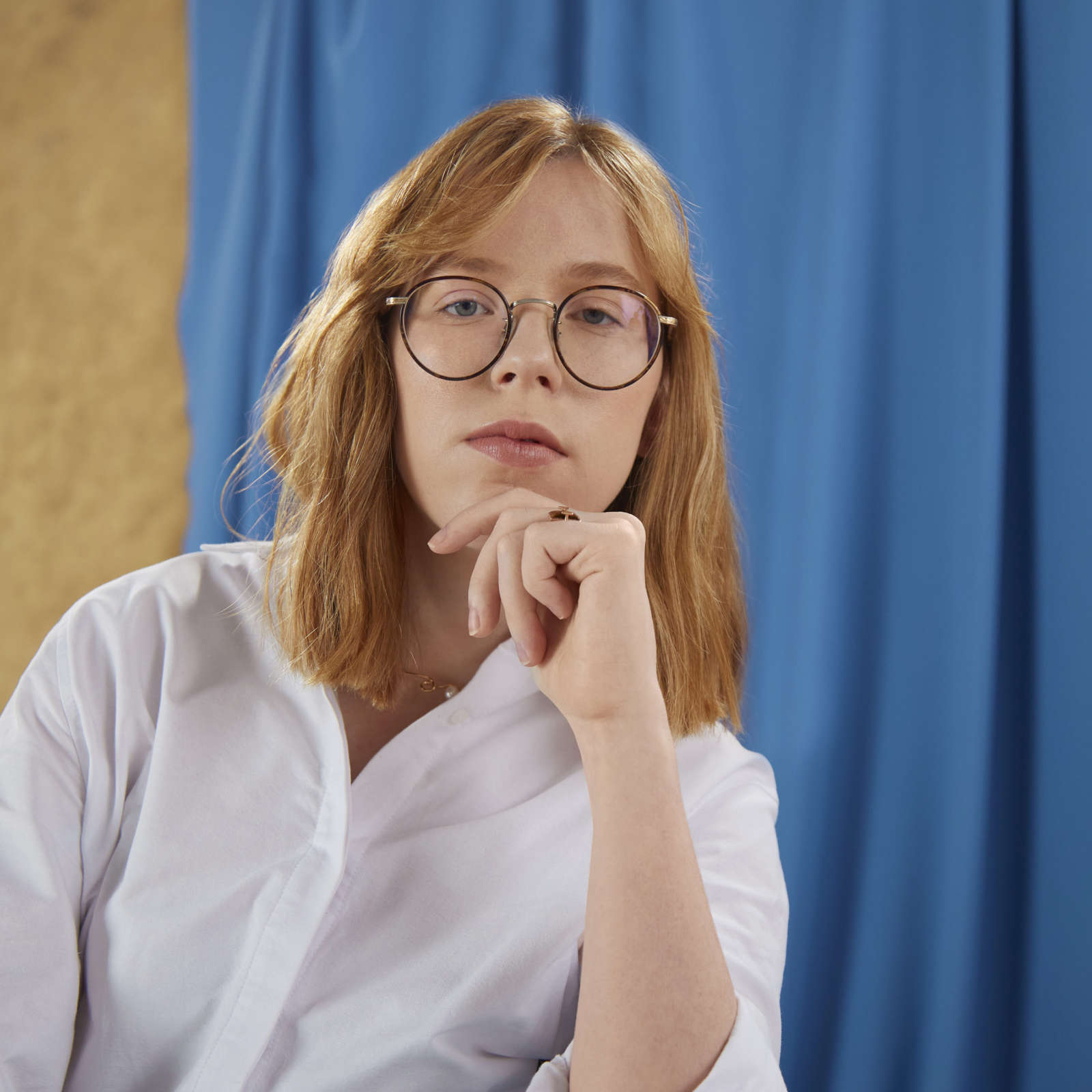 Grace wears white shirt, stares at camera